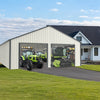 Double garage metal shed with side entry door, housing green tractors, against a scenic backdrop of a modern white house and lawn.